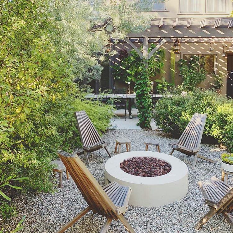 Backyard fire pit on pea gravel with vine wall