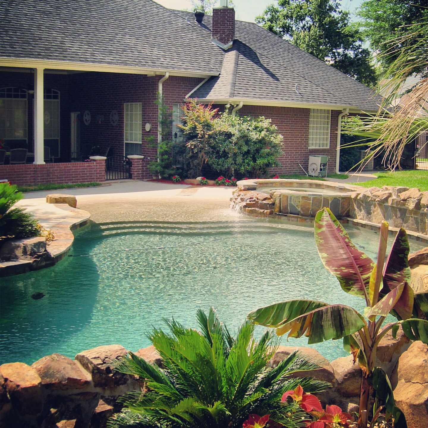 Backyard oasis by Preferred Pools  with boulder stone coping and spa ...
